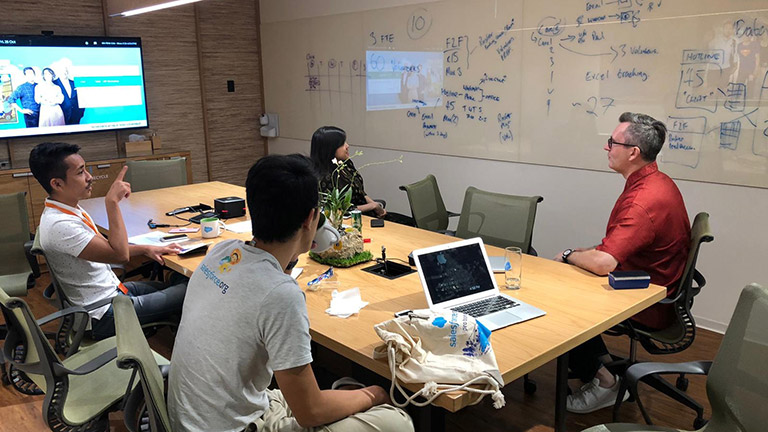 Paul whiteboarding in a meeting with colleagues