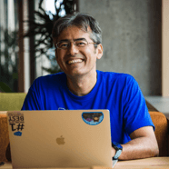 man smiling working on a laptop