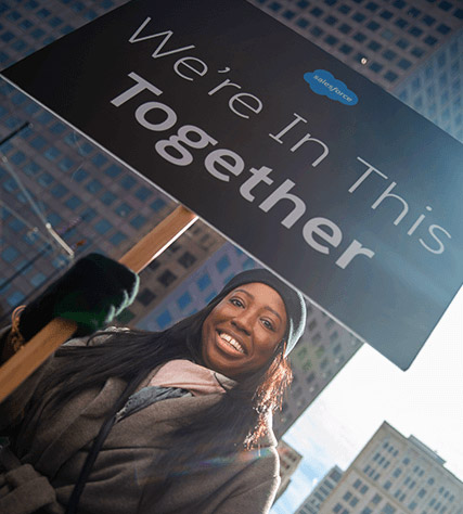 woman marching with we're in this together sign