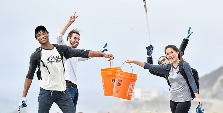 futureforce interns working together on a beach cleanup