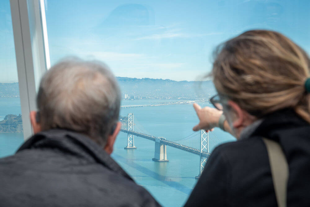Angela Little looks out at bay bridge from Ohana Floor at Salesforce Tower San Francisco.
