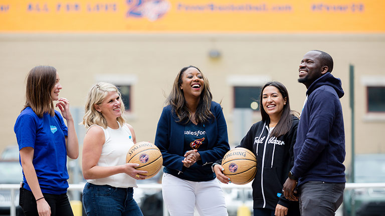 Kai Johnson laughing with colleagues on a basketball court