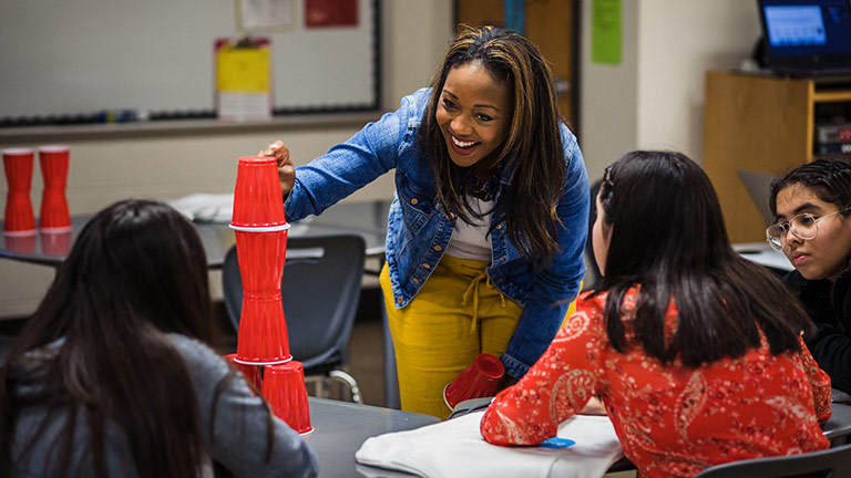 Kai Johnson speaking with students in a classroom.