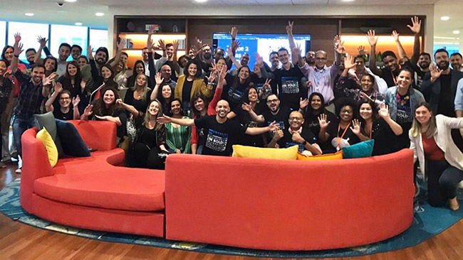 Johnny with a big group of salesforce employees waving at the camera